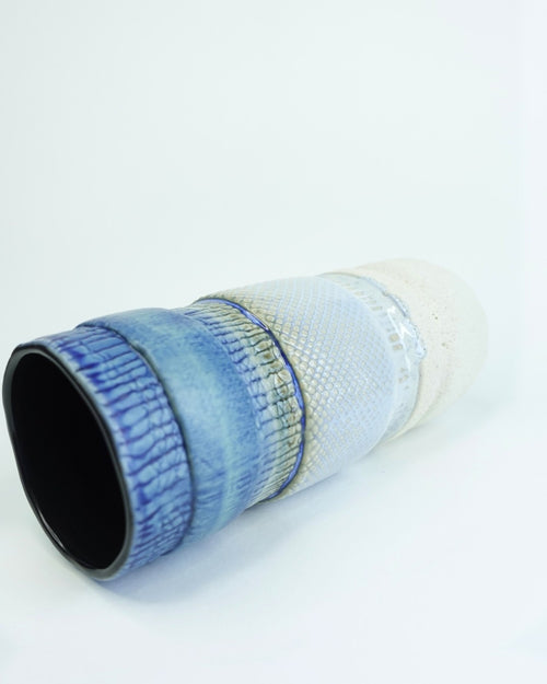 Jarrón de cerámica artesanal Bruma para Koba Studio. Pieza única de 40 cm inspirada en la niebla marina, con esmalte azul y blanco.