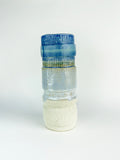 Decorative glass bottle with textured design on a white background