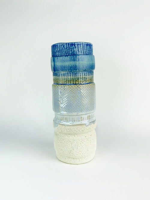 Decorative glass bottle with textured design on a white background