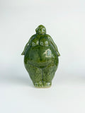 Green ceramic figure on a white background